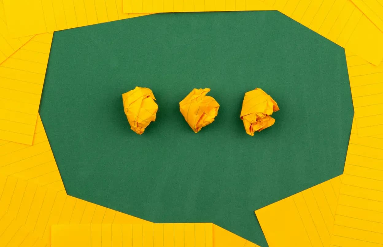 Speech callout bubble, with the entire canvas being textured with construction paper, and the speech dots in the bubble being crumpled balls of paper